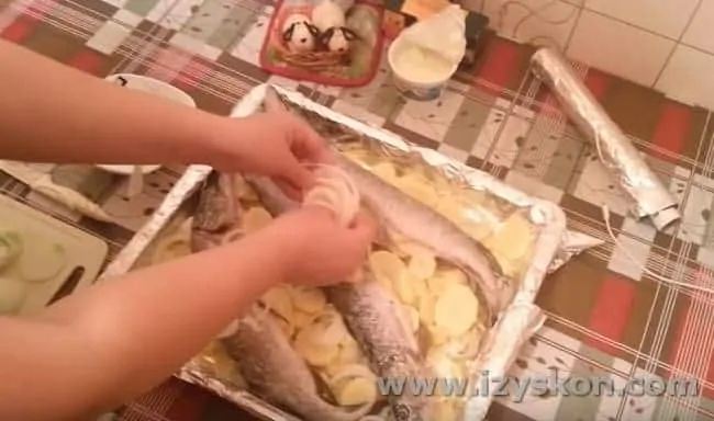 Поверх рыбы раскладываем кольца лука.