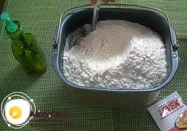 Всыпьте в форму 920 г муки и аккуратно перемешайте